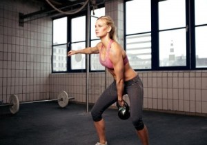 14157960-giovane-fitness-donna-adulta-fare-esercizio-swing-con-un-kettlebell-come-parte-di-un-allenamento-cro